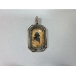 A gold leaf sillhouette and diamond set pendant, the octagonal glazed and closed back panel