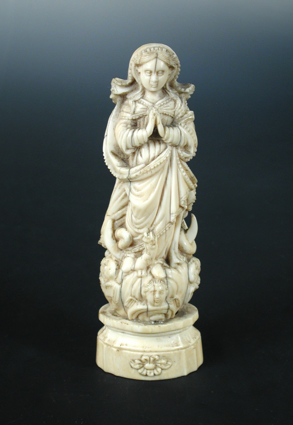 A carved ivory Indo-Portuguese Madonna, probably Goan 19th century, carved with hands folded in