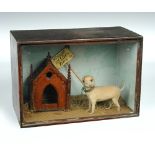 An early 20th century taxidermy novelty of a miniature dog, mounted as a guard dog chained to a