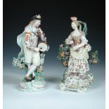 Two patch marked Derby figures of musicians, he stands on a circular base beating a tambourine and