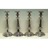 A set of four Old Sheffield plate candlesticks, each raised from a circular foot with applied band