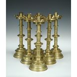 A set of six Victorian Gothic style brass candlesticks, stamped Jones & Willis, each with