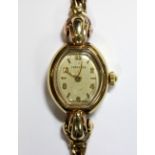 Longines - a lady's 9ct gold wristwatch, the champagne coloured barrel shaped dial with mixed gold