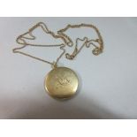 A circular locket on fine ropetwist longchain, the slim locket engraved on one side with the