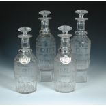 A set of four 19th century decanters and stoppers, bands of facetting on the feet and shoulders