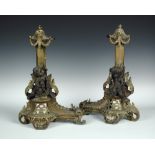 A pair of 19th century gilt and patinated metal chenet, each with lion mask terminal above a