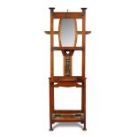 An Arts & Crafts walnut hall stand, the back with mirror and hook arrangement above an enamelled
