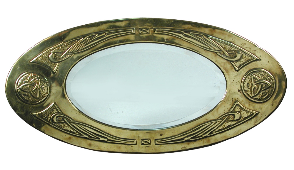 A Scottish School brass framed wall mirror, the oval bevelled glass with brass frame embossed with