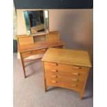 A mid-20th century dressing table and a similar chest of drawers, the table with shaped triptych