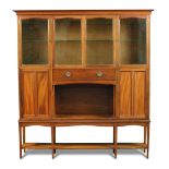 Liberty & Co., a walnut cabinet on stand, the upper section with four glazed doors above a central