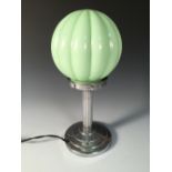 An Art Deco table lamp, the chromed fluted column to a stepped circular foot with pale green glass