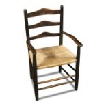 Attributed to Ernest Gimson, a rush seated child's ladder back chair, the ash frame with twin