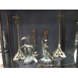 A pair of bronze figure groups of dolphins, together with a pair of bronze caricature candlesticks