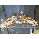 A pair of mid 20th century Chinese carved hardwood figures of reclining fishermen on hardwood