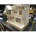 A modern dolls house together with furniture and other items including magazines and books