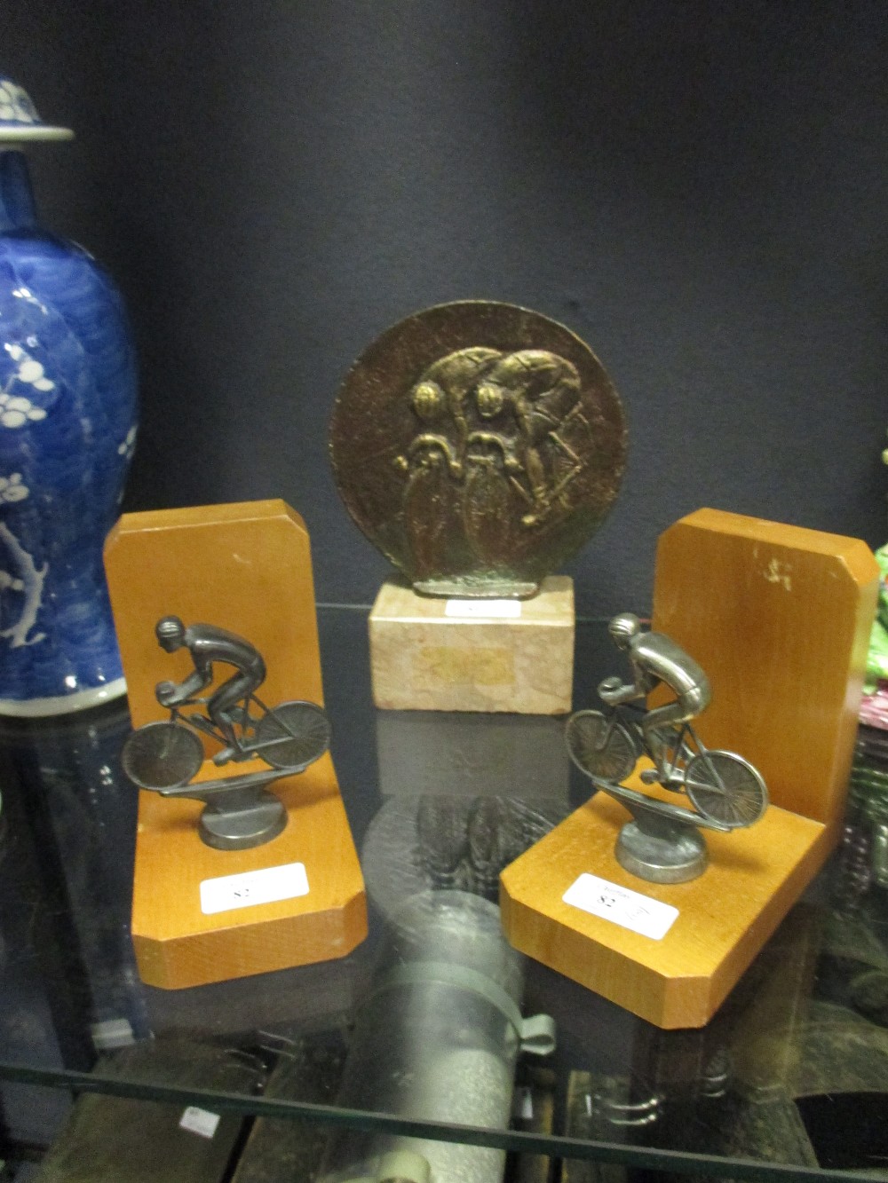 A bronze cycling trophy, together with a pair of cycling bookends (3)