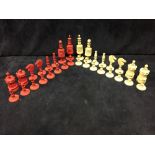 A 19th century Indian bone chess set, the red and white pieces ring turned, the kings 9.5cm (3.75
