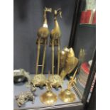 A pair of Chinese polished brass stork and turtle candlesticks, brass twinned carps, a Buddhist lion