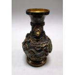 A parcel gilt bronze vase, the baluster shape cast in relief with two dragons amongst clouds, the