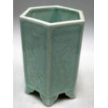 A pale celadon hexagonal brush pot, each side panel moulded in low relief with a different flowering