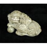 A 19th century ivory figure of a lion dog, the hair of the reclining animal carved in luxuriant