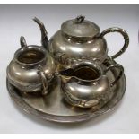 An early 20th century silver three piece tea set by CCI, the bun shaped bodies with dragons in