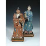 A pair of late 19th century nodding figures, both carrying vases and wearing floral robes, hers with