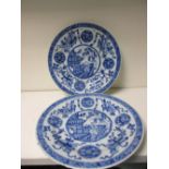 A pair of 18th century blue and white plates, each centrally painted with a boy waving from a roof
