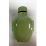 A jade snuff bottle and stopper, the misty green stone carved into a flattened ovoid shape flanked