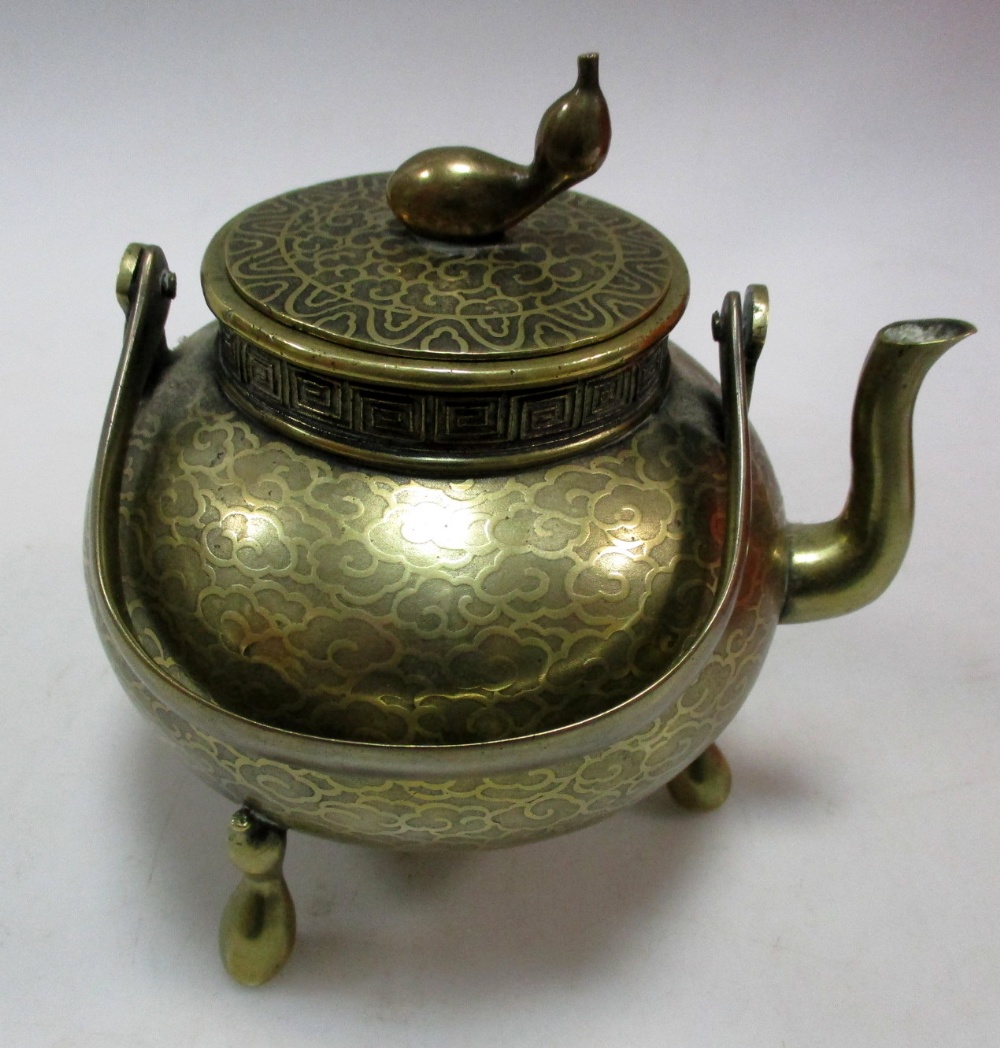 A polished bronze kettle or tetsubin and cover etched with stylised clouds, the double gourd cover