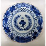 A blue and white dish, period of Kangxi, the central wreathed pair of flowers within diamond hatched