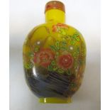 An amber glass snuff bottle, an agate snuff bottle and another, the first painted on one side with