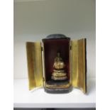 A late 19th/early 20th century black lacquer shrine, the hinged doors opening onto a gilt figure