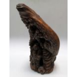 A late 19th/early 20th century bamboo carving of a young man below pine trees growing amongst rocks,