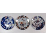 A pair of mid 18th century Imari plates and another, the pair with cherry flowering by a rosette