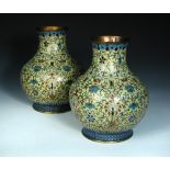 A pair of mid 19th century cloisonne bottle vases, the yellow grounds decorated with lotus scrolling