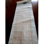 A calligraphy scroll the six column inscription in terracotta red, 111 x 38cm (43.75 x 15 in)