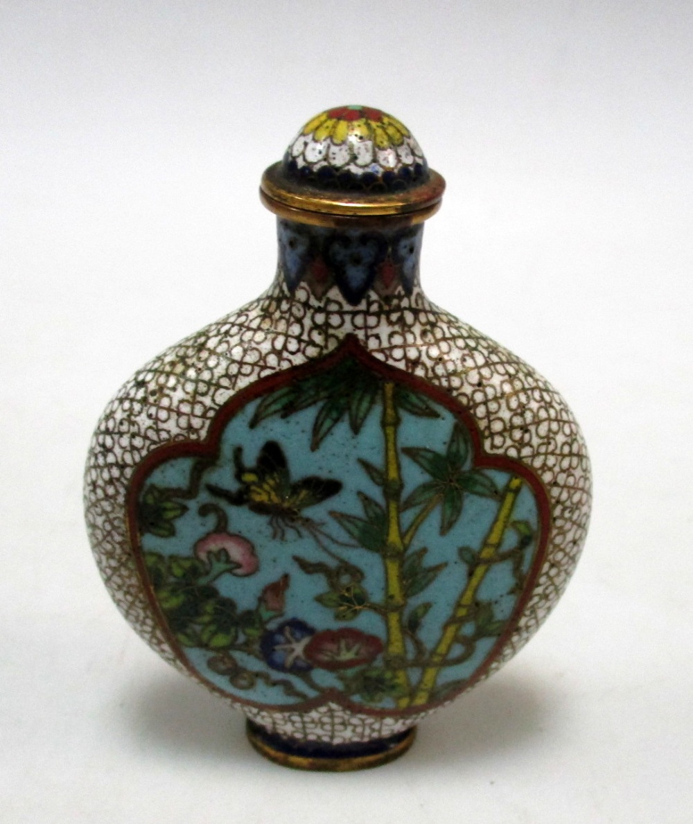 A cloisonne snuff bottle and stopper worked with two turquoise ground reserves of gardens on a white