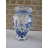 An 18th century Delft blue and white jug, the ovoid body painted with towers and houses in an