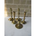 A pair of 18th century brass petal based candlesticks, a pair later and a single candlestick, the