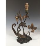 An Art Nouveau bronze lamp as a stork amidst foliage, modelled picking at leaves to a foliate