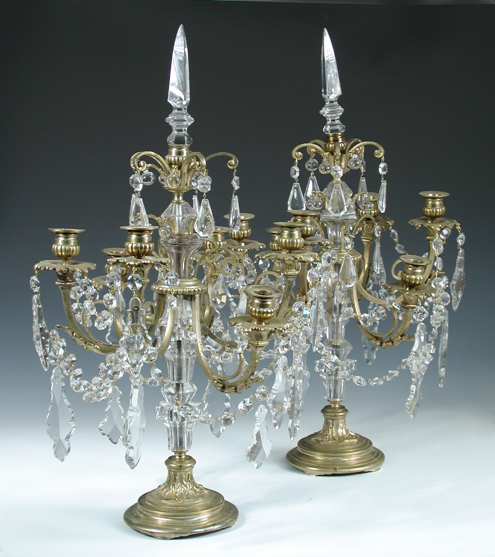 A pair of gilt metal and glass table lustres, early 20th century, each with facet cut shaped central