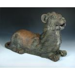 A late 19th/early 20th century terracotta lioness, her tail tip resting on her rear flank as she