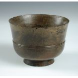 A lignum vitae bowl, the tapering rounded sides with central reeding above a short cylindrical foot,