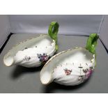 A pair of Meissen leaf pattern sauce boats with rustic handles, the bodies with floral decoration,