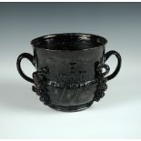 A '1776' Wrotham black glazed two handled mug, initialled EWE and dated between vertical frilled