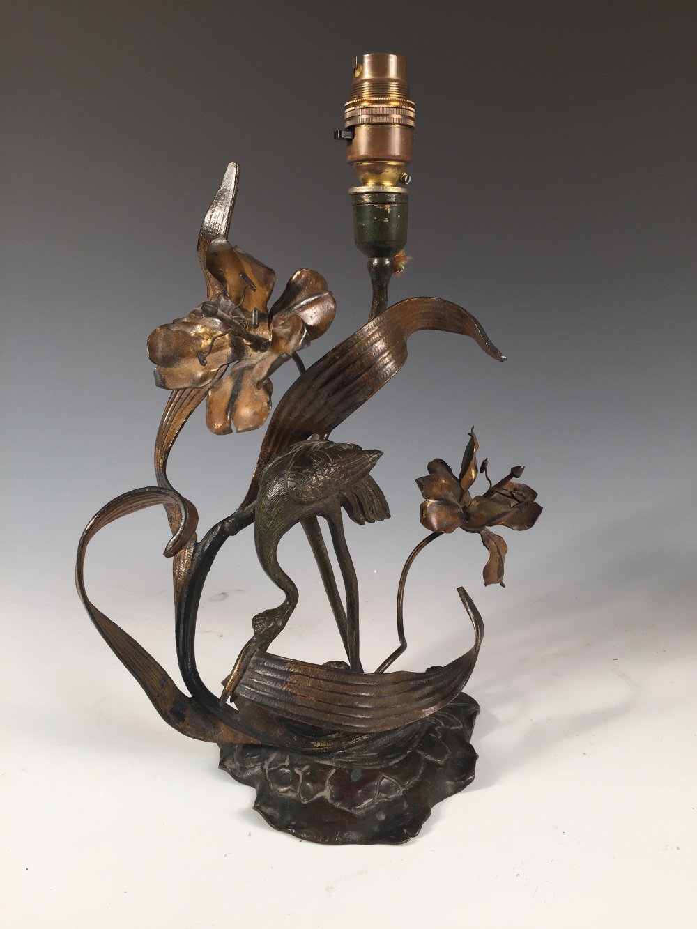 An Art Nouveau bronze lamp as a stork amidst foliage, modelled picking at leaves to a foliate - Image 2 of 2