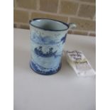 An 18th century Delft blue and white glass bottomed mug, the cylindrical sides painted with a