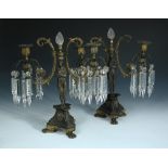 A pair of parcel gilt bronze lustre candelabra, each with central figure supporting two arms and cut