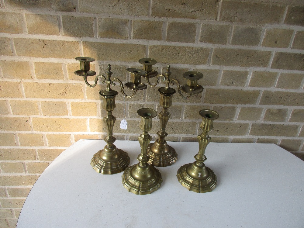 A pair of 18th century French or Dutch brass candelabra and a matching pair of candlesticks, each